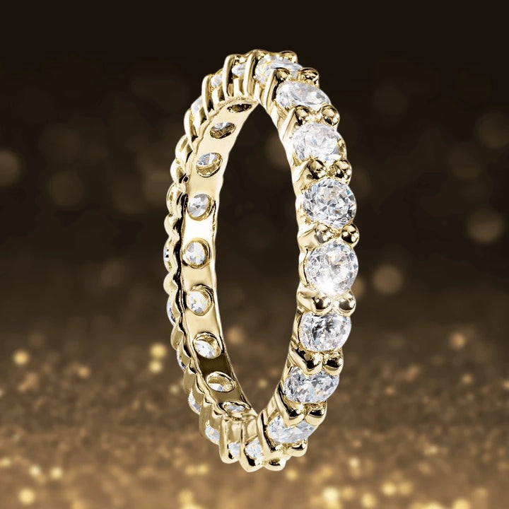 Gold Millionaire Tennis Eternity Ring in sterling silver with gold plating, featuring sparkling clear stones set in a continuous band designed for women’s jewelry.