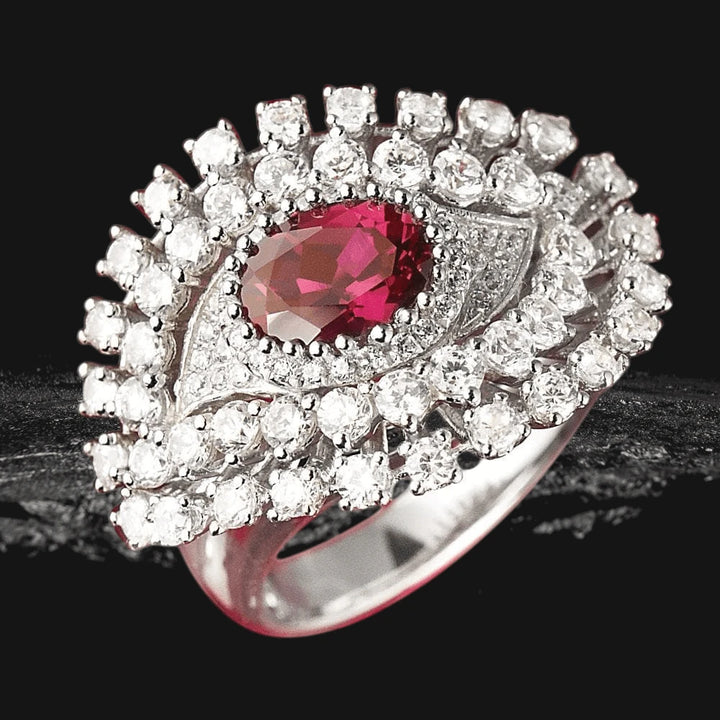 Nazar Rouge Ring featuring a sterling silver band with a central deep red gemstone surrounded by sparkling clear stones, designed for women’s fine jewelry collections.