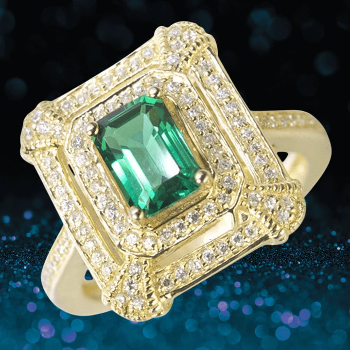 Taylor Ring featuring a gold-plated sterling silver band adorned with a vibrant emerald-cut green gemstone surrounded by intricate sparkling accents, designed for women’s jewelry.