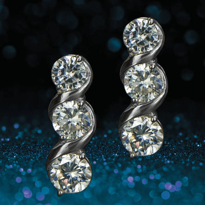 Solitaire Twist Earrings featuring three sparkling stones each, set in sterling silver with rhodium plating for a luxurious, elegant female jewelry piece.