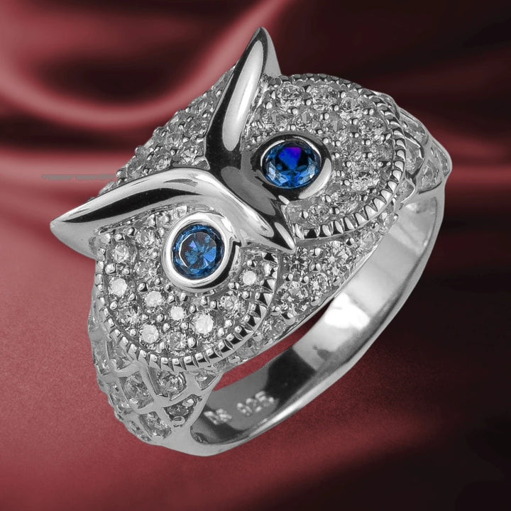 Owl Rhodium Ring crafted in sterling silver with rhodium plating, featuring intricate detailing and blue gemstone eyes, designed for women’s jewelry collections.