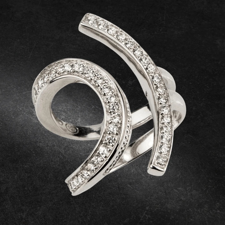 Lola Ring Rhodium featuring a modern spiral design crafted from sterling silver with rhodium plating, adorned with sparkling clear stones for elegant jewelry appeal.
