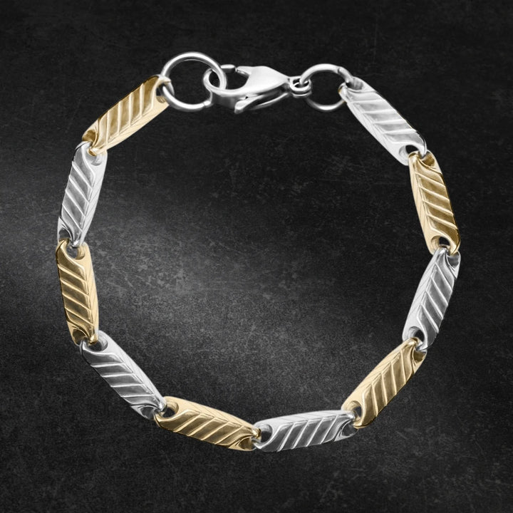 Chevron Steel Bracelet featuring a two-tone stainless steel design with alternating gold and silver chevron links, secured by a lobster clasp for a masculine jewelry statement.