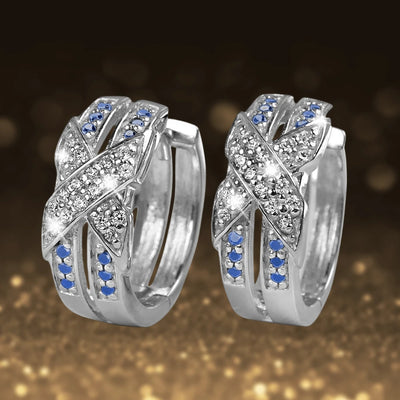 Embrace Rhodium Earrings crafted from sterling silver with rhodium plating, featuring intertwined bands adorned with clear and blue gemstones for a refined feminine style.
