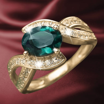 Arisia Ring featuring a gold-plated sterling silver band with an oval deep green gemstone centerpiece accented by sparkling clear crystals, designed for women’s jewelry.