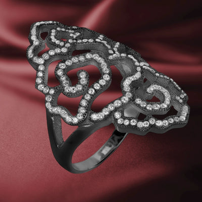 Desert Rose Black Ring crafted from sterling silver with an intricate openwork floral design adorned with sparkling clear stones, displayed on a rich burgundy fabric background.