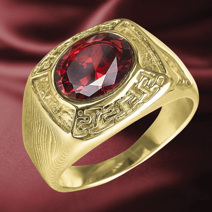 Inferno Men's Ring featuring a bold gold-plated stainless steel band with intricate design details and a large faceted deep red gemstone centerpiece, a striking piece of jewelry.