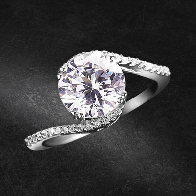 Embrace Solitaire Ring in sterling silver with rhodium plating, featuring a large round solitaire stone and a delicate band adorned with smaller sparkling stones for women’s jewelry.