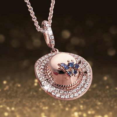 Memories Of Summer Pendant in sterling silver with rose gold plating, featuring a detailed hat design embellished with sparkling crystals and blue gemstone accents on a delicate chain.