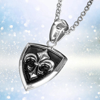 Grand Canyon Steel Pendant featuring a stainless steel shield design with a raised fleur-de-lis emblem, suspended on a matching chain for a striking men's jewelry piece.