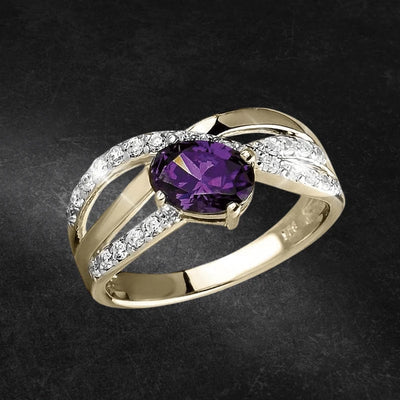 Ladies' Carolina Ring featuring a sterling silver band plated in gold, adorned with a central purple gemstone and sparkling clear accent stones in an elegant design.
