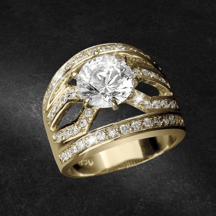 Malaga Golden Ring featuring a sterling silver base plated in gold, adorned with a large central clear gemstone and multiple smaller sparkling stones, designed for women’s jewelry.