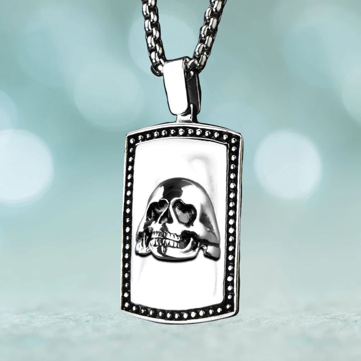 Skull Pendant featuring a detailed skull design on a rectangular stainless steel plate with beaded edge, suspended from a matching polished chain for men’s jewelry.