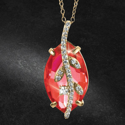 Fire Vine Pendant featuring a sterling silver gold-plated vine design with sparkling crystals set over a vibrant red gemstone, elegantly crafted for women’s jewelry.