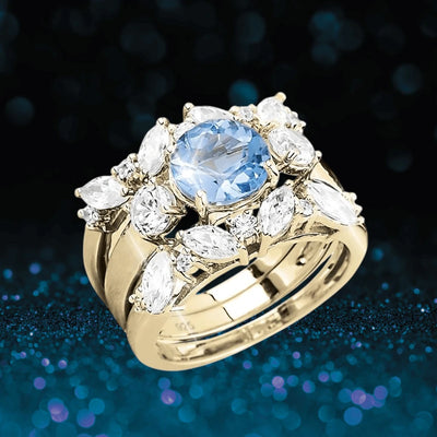 Isla Blue Topaz Trio Bridal Ring featuring a sterling silver band with gold plating, adorned with a central blue topaz gemstone surrounded by sparkling clear stones, designed for women.
