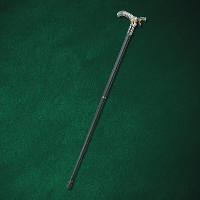 Black Fang Walking Cane with a sleek black shaft and a silver handle featuring a detailed wolf head design, resting on a dark green surface.