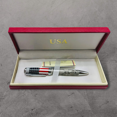 The American Journey Pen displayed in an elegant red and cream gift box with a USA emblem, featuring a patriotic design with an American flag and detailed engravings.