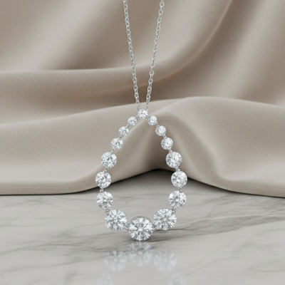 Silver necklace with a circular pendant on a beige fabric background. Daniel Steiger To Catch A Thief Pendant