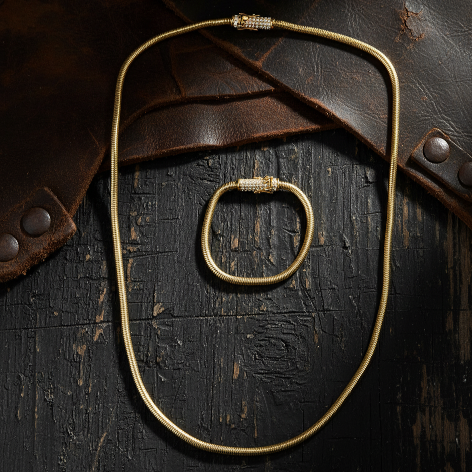 Gold necklace on a textured dark surface with leather accents