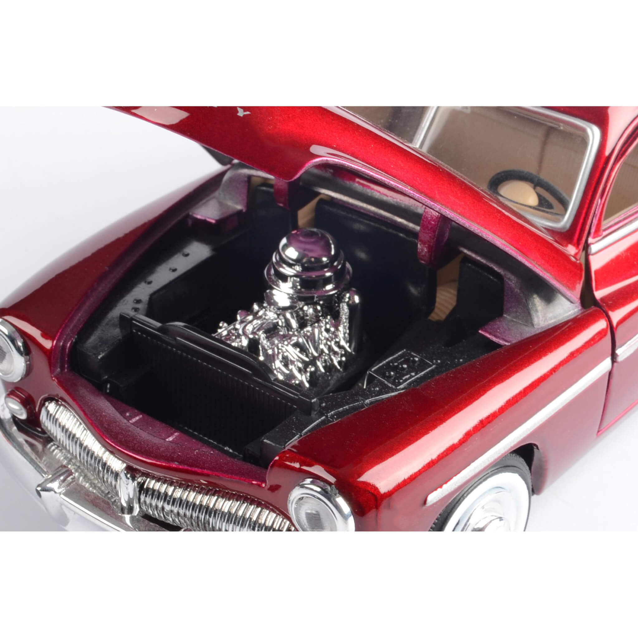Close-up of a red car model with an open hood displaying a silver engine.