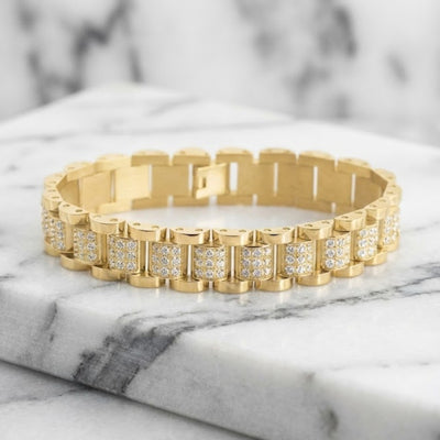 Gold bracelet with diamond accents on a marble surface. Daniel Steiger Marcos Men's Bracelet