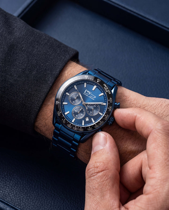 Close-up of a hand adjusting the Midnight Velocity Men's Watch with a sleek blue metal band and chronograph dial, showcasing a modern design ideal for stylish watch collectors.