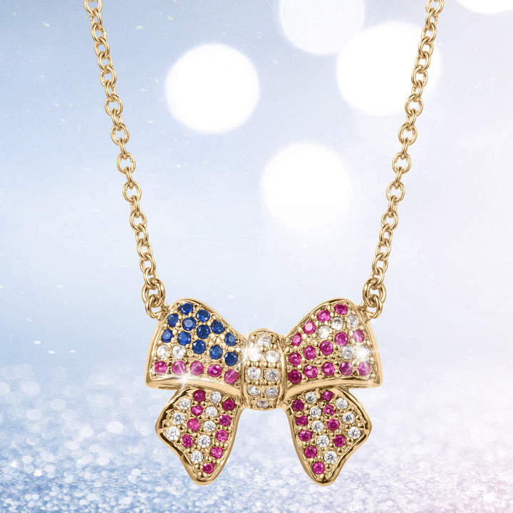 Delicate gold bow-shaped pendant adorned with blue, pink, and white gemstones on a fine chain, part of the Heritage Bow Collection jewelry.