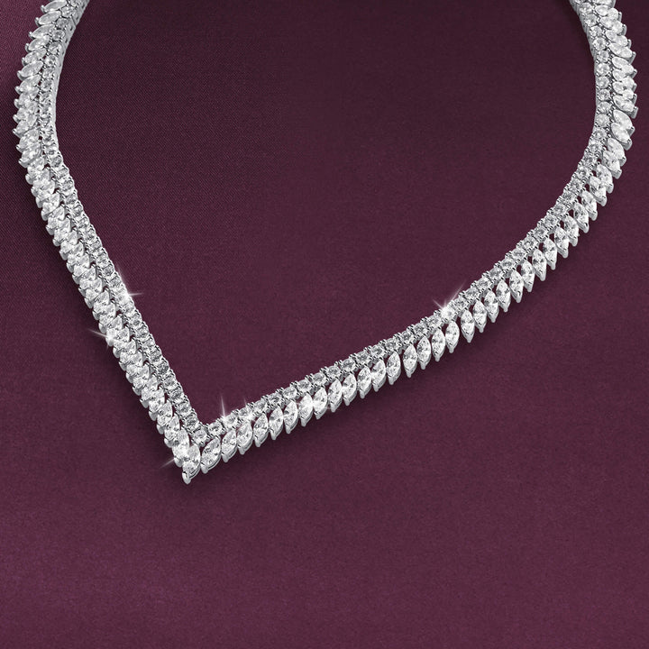 Crystal Cascade Necklace featuring a sparkling silver tone V shaped design with rows of clear faceted stones on a rich burgundy background Up To 75% Off Retail