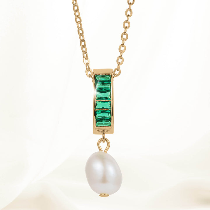 Elegant gold chain necklace featuring a rectangular pendant with green gemstones and a dangling white pearl from the Pearl Radiance Collection