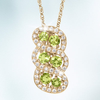 Elysian Peridot Pendant featuring vibrant green peridot stones set in a sparkling gold design with surrounding clear crystals, available Up To 75% Off Retail.