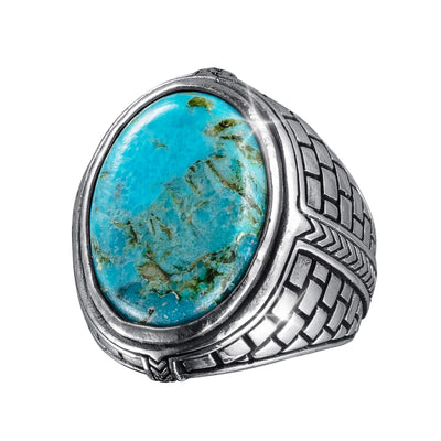 Turquoise Frontier Ring featuring a large oval turquoise stone set in a silver band with intricate woven and geometric patterns, combining bold style with southwestern elegance.