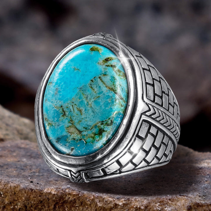 Turquoise Frontier Ring featuring a large oval turquoise stone set in a detailed silver band with an intricate woven pattern, ideal for jewelry and ring collectors.