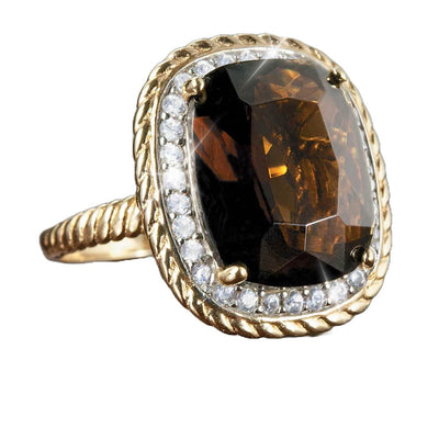 Chocolat Twist Ring featuring a large dark brown faceted stone surrounded by small clear crystals set on a twisted gold plated sterling silver band designed for women.