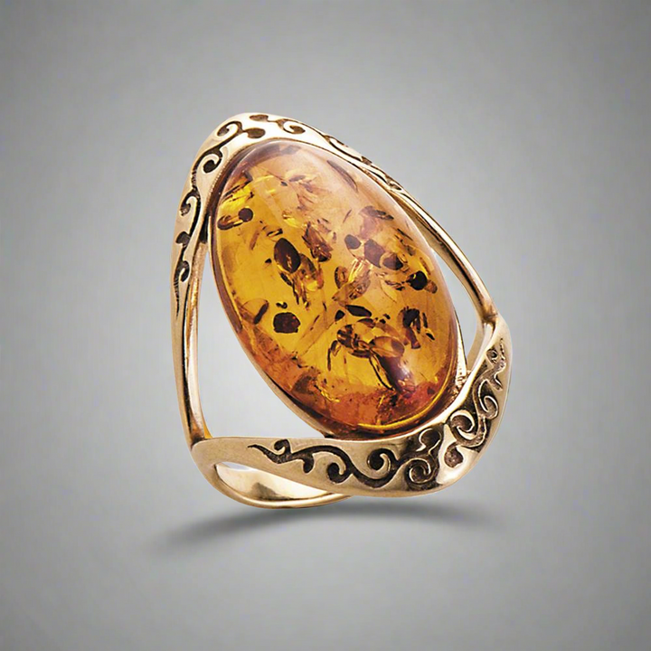Baltic Amber Ring featuring a large polished amber stone set in an intricately designed gold-plated sterling silver band, crafted for female wearers.