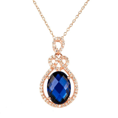 Rosa De Mer Pendant featuring a deep blue faceted stone surrounded by rose gold plated sterling silver with sparkling accents, designed for women’s jewelry collections.