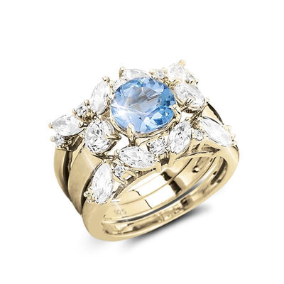 Isla Blue Topaz Trio Bridal Ring featuring a sterling silver band with gold plating, adorned with a large blue topaz center stone surrounded by marquise and round clear crystals.