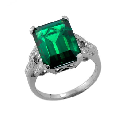 Hutton Ring featuring a large emerald-cut green gemstone set on a sterling silver band plated with rhodium, designed for women, with intricate detailing on the shoulders.