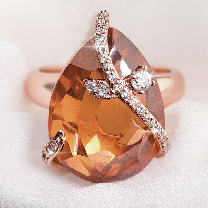 Close-up of a Fire and Ice Ring featuring a large teardrop-shaped gemstone set in sterling silver with rose gold plating, accented with small sparkling stones for a feminine jewelry piece.