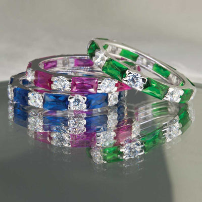 Three elegant rings stacked together featuring rectangular gemstones in green, pink, and blue, accented with sparkling white stones, crafted in rhodium-plated sterling silver, showcasing the Palm Beach Stacker Rings Green.