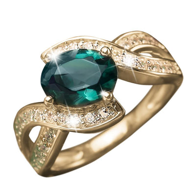 Arisia Ring featuring a sterling silver base with gold plating, adorned with a large green gemstone centerpiece and sparkling accent stones, designed for women’s jewelry.