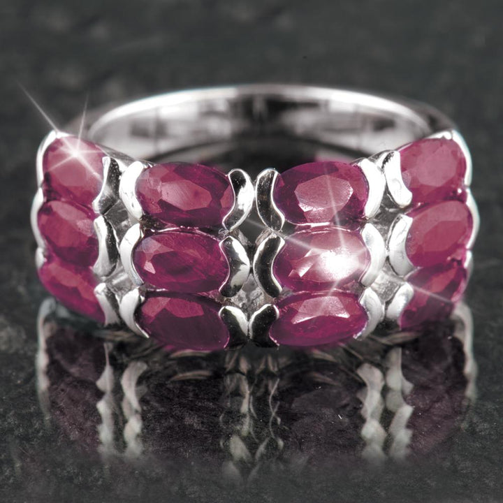 Ruby Band Ring featuring multiple oval-shaped red ruby gemstones set in sterling silver with rhodium plating, designed for women’s elegant jewelry collections.