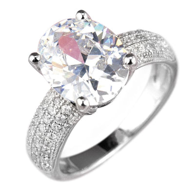 Caravella Rhodium Ring featuring a sterling silver band with rhodium plating, adorned with a large sparkling oval-cut center stone and smaller pavé-set stones on the band.